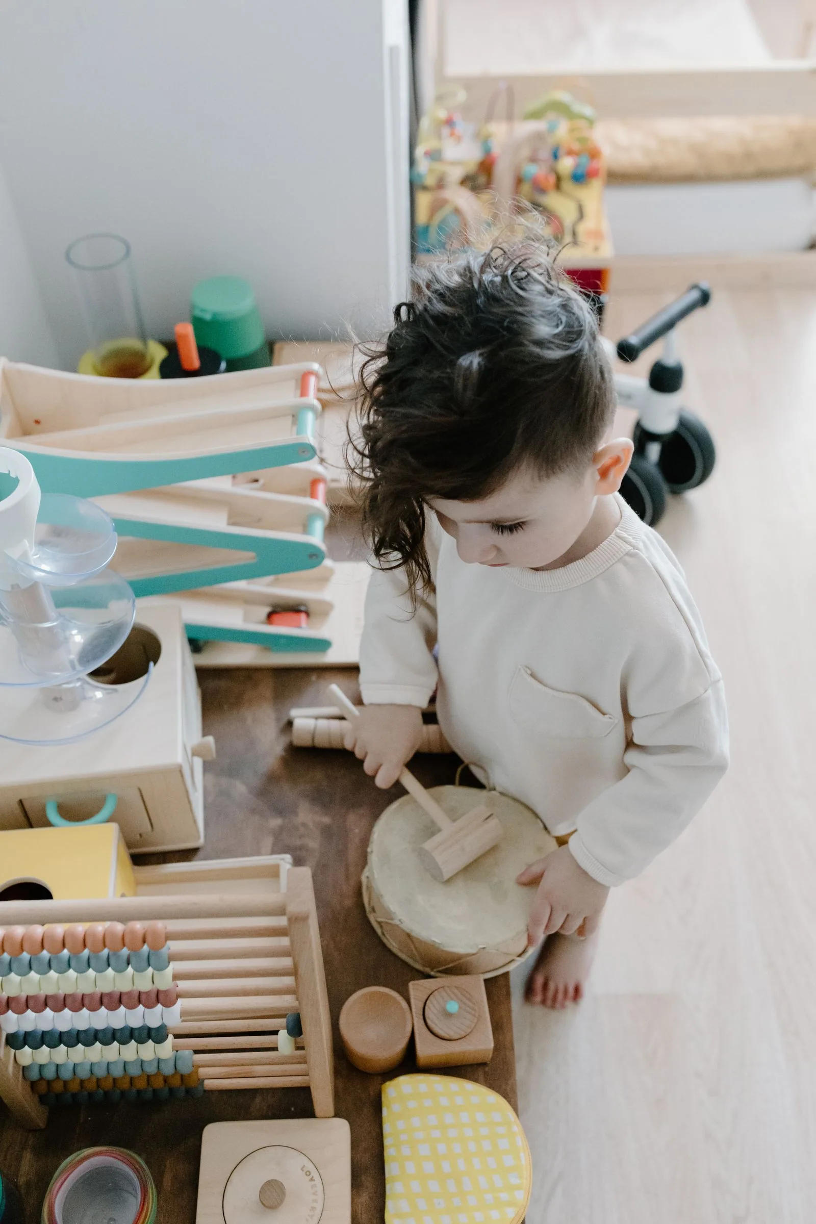Child playing with wooden toys in a sunlit playroom