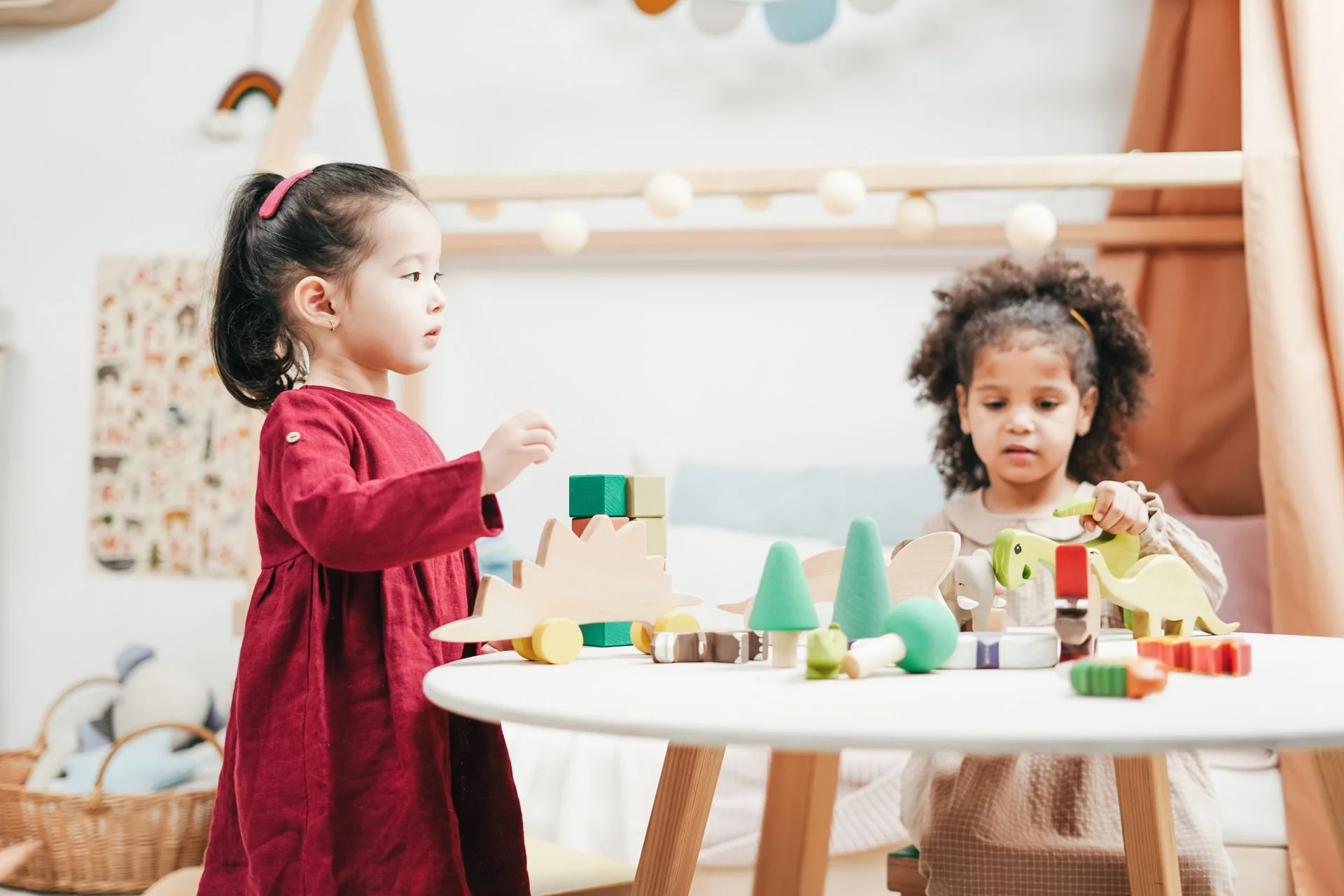Two children playing together with wooden toys