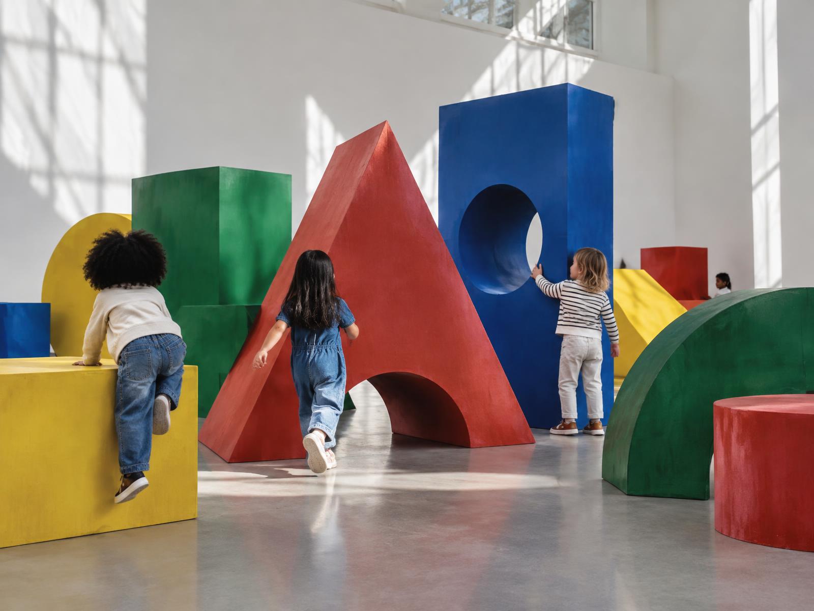 Children exploring large geometric forms